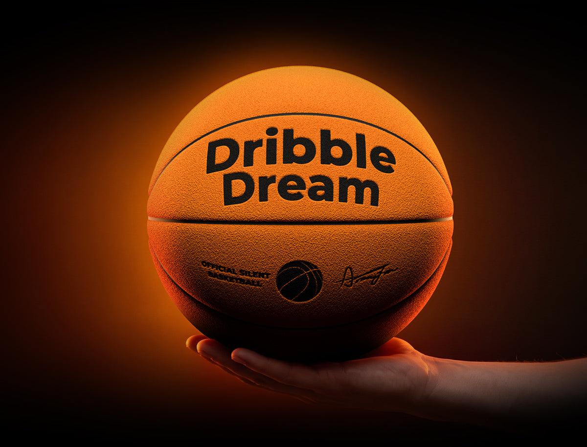 Hand holding the orange Dribble Dream silent basketball in an orange glow